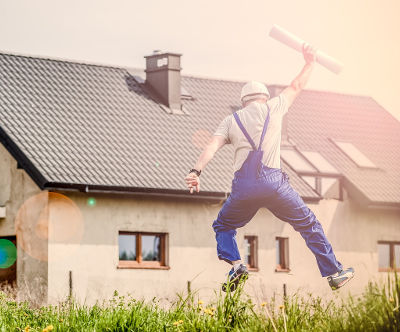 homme qui saute devant une maison